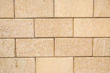 The background of the wall is made of rectangular tiles of natural beige seashell with a beautiful stone pattern. Backgrounds texture design.