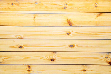 The background is made of planed larch boards of yellow color with beautiful knots and a pattern of the tree structure. Design backgrounds textures construction.