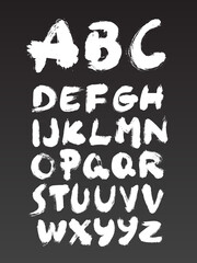 Ink brush calligraphy font alphabet on dark background