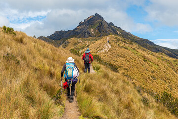 People on a trail walking the high altitude Rucu Pichincha hike in the Andes mountains, Pichincha volcano, Quito, Ecuador. - obrazy, fototapety, plakaty
