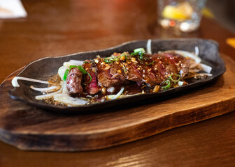 Beef teriyaki on a luxury scale in a restaurant with blurred background