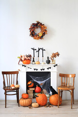 Halloween, fireplace with a variety of festive decor and pumpkins.