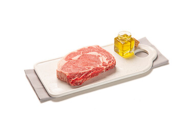 filete de lomo de ternera fresco y crudo sobre un plato blanco y una servilleta de tela gris, aislada fondo blanco