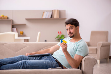Young male freelancer in e-commerce concept