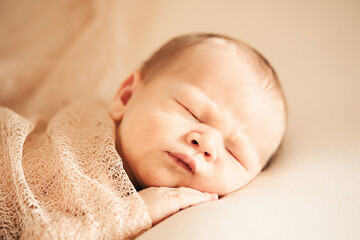 A newborn baby sleeping on a soft white background. Childhood or parenting concept. Soft focus, copy space.