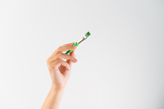 Greenwashing concept. Green pain and brush. Environmental marketing disinformation. Non transparent green sheen.