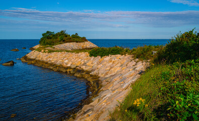 The curved jetty stretching out into the blue sea connecting the Knob island on Cape Cod