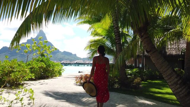 Travel video concept. Bora Bora Vacation woman walking on motu beach on in French Polynesia with Mount Otemanu. Lady on luxury holiday in overwater bungalow resort hotel
