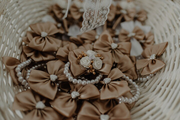 Pile of brown bow and pearl decorations in a basket