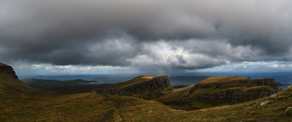 Panorama of moody rocky landscape of landslide Quiraing on a rainy autumn day, Isle of Skye,...