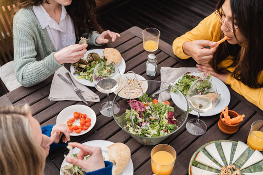 Young Multiracial Friends Eating And Drinking Healthy Food Outdoor At Patio Restaurant - Focus On African Girl Face