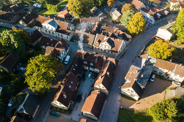 Obraz premium Aerial view of old town in city Kuldiga and red roof tiles, Latvia. Sunny autumn morning.