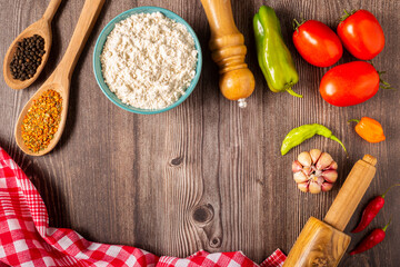 Wooden table with ingredients for pizza.