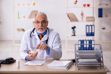 Old male doctor working in the clinic