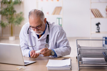 Old male doctor working in the clinic