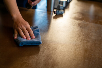 Asian man barista using towel sweeping counter bar with alcohol sanitizer before opening cafe. Male coffee shop owner cleaning up table for service to customer. Small business owner working concept