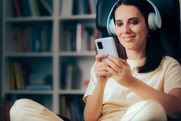 Happy Woman Holding Smartphone Listening to Music at Home