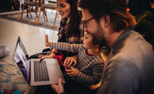 Family giving Christmas greeting to friends over a video call