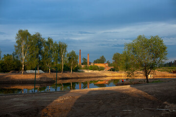 A pond excavated in the city. Water and shore. The lake at sunset.