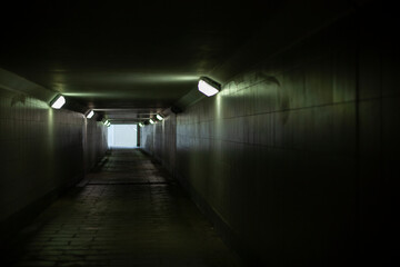 Tunnel under the road. Underground pedestrian crossing. A light in the end of a tunnel.