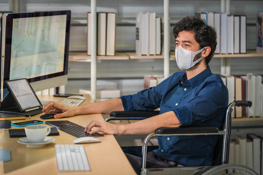 Disabled Financial Executive On Wheelchair With Mask Working In Financial Company