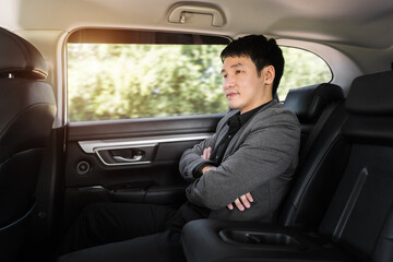 business man sitting at the back seat of car