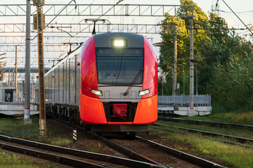 Naklejka premium Front view of modern russian intercity high speed train on railway platform. Industrial landscape with passenger train on railroad in Europe. Commercial suburban transportation concept