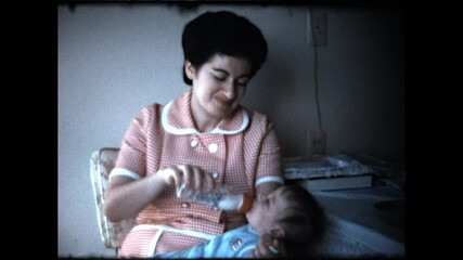 Mother Bottle Feeds Infant - A mother bottle feeds her newborn baby boy. 