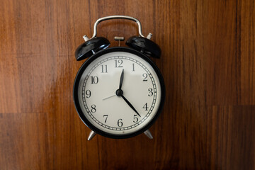 alarm clock on the table with wood background