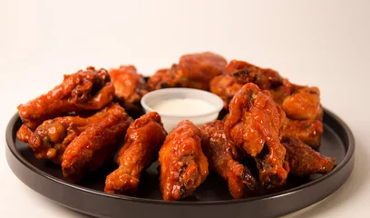 Foto op Plexiglas Hot and spicy buffalo chicken wings close up on a white background © AokiSuko