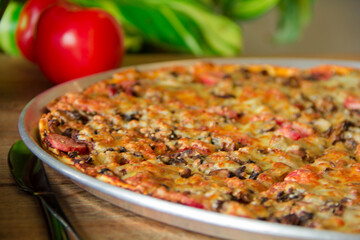 Rustic artisan flatbread pizza topped with cured meats and fresh herbs, captured in a warm and detailed close-up.