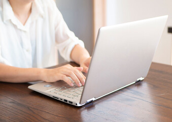 Fototapeta premium 自宅でテレワークをする人の手元とパソコン画面のクローズアップイメージ