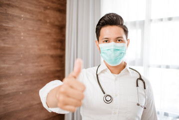 Fototapeta na wymiar man doctor wearing medical mask standing looking at camera