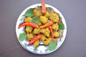 closeup the bunch yellow brown bengal gram fried food with red chilly and green mint in the steel...