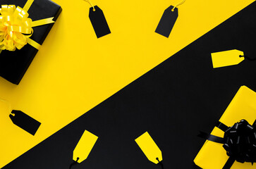 Yellow and Black gift boxes with ribbon and blank price tags put on black and yellow background. Black friday and Boxing day concept.