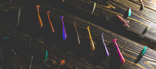 Silicone fish bait on a wooden background. Toned photo studio. © BearOK