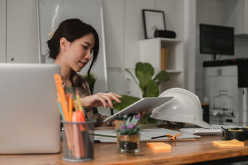 Woman architect designer structural engineer working office looking tablet discussing building plan...