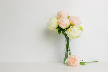 A bouquet of white and pink rose flowers in vase over the white background. 