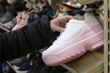 Casual women's shoes. Sneakers in the hands of a close-up