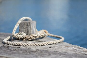 Naklejka premium A mooring line around a bollard on a wooden pier