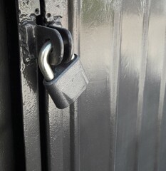 Padlock on black metal gate close-up