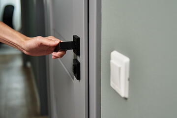 Woman open white door with a handle and entrance in the room.Element of interior