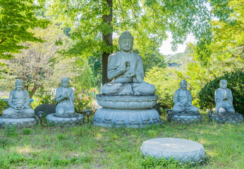 Large stone carved Buddha flanked by four smaller Buddhas