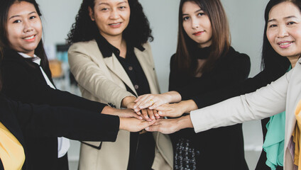 Close up shot of holding hands of middle aged successful confident female businesswoman colleagues...