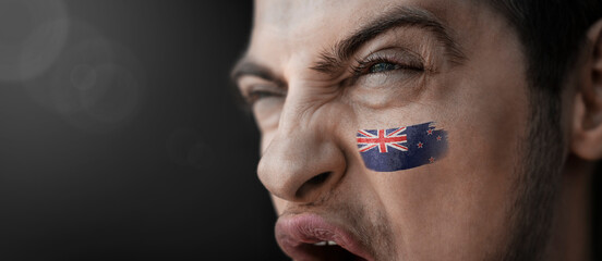 A screaming man with the image of the New Zealand national flag on his face