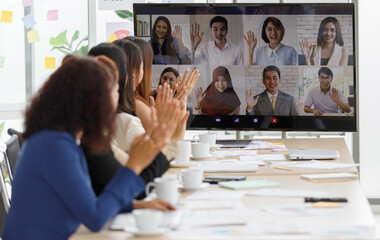 Close up shot of multicultural businessman businesswoman colleagues on teleconference on monitor screen greeting say hello to female officer staffs group in formal suit sitting waving hands together - obrazy, fototapety, plakaty