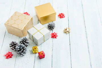 gift boxes and pine cones on white wooden