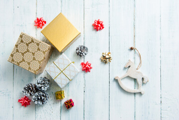 gift boxes and pine cones on white wooden