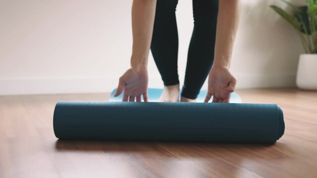 B roll of woman roll out yoga mat for preparation, Female work out by exercise yoga in living room at home.