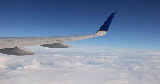 Wing of an airplane flying above the clouds of aircraft